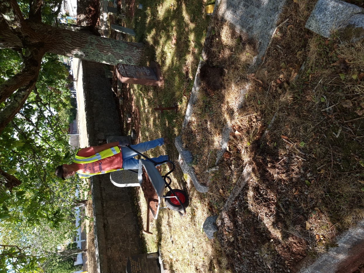 Pete using his wheelbarrow to fill the sunken graves